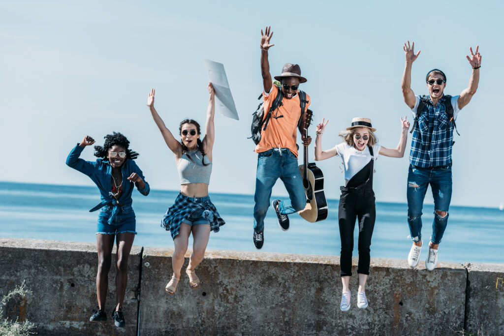 a group of young friends jumping of parapet together