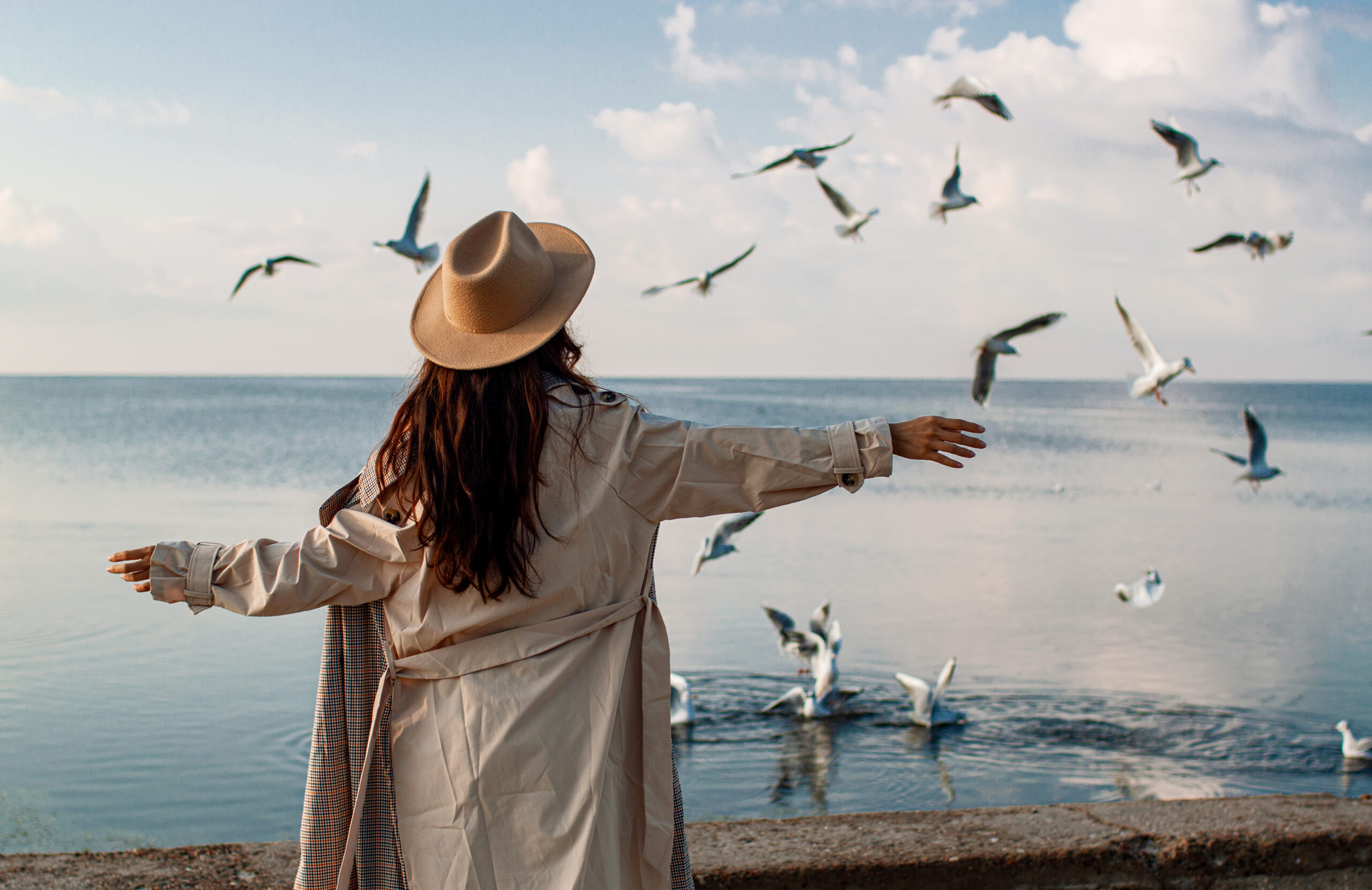optimising ecotourism Mediterranean to care med what we achieve banner to care med - a woman with hands up in the air walking in a beach with a birds